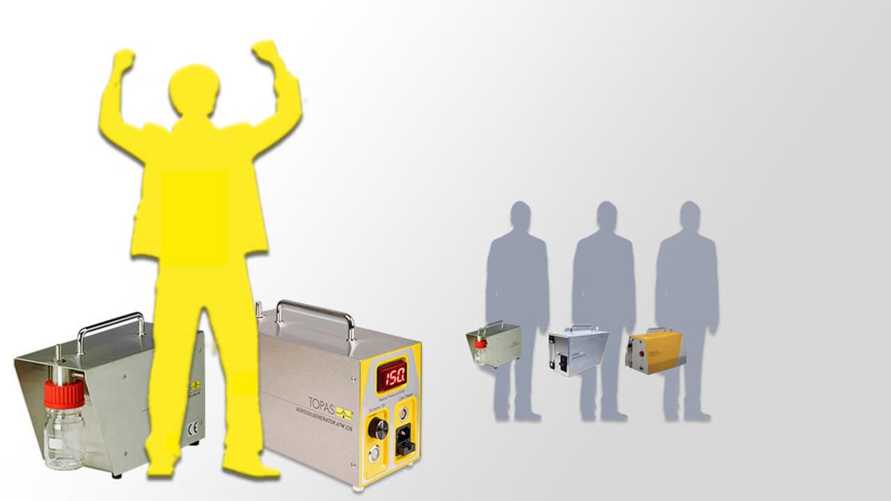 Jubelnde gelbe Figur vor ATM 228 und ATM 226, dahinter drei kleine graue Figuren stehend mit älteren Aerosolgeneratoren in der Hand